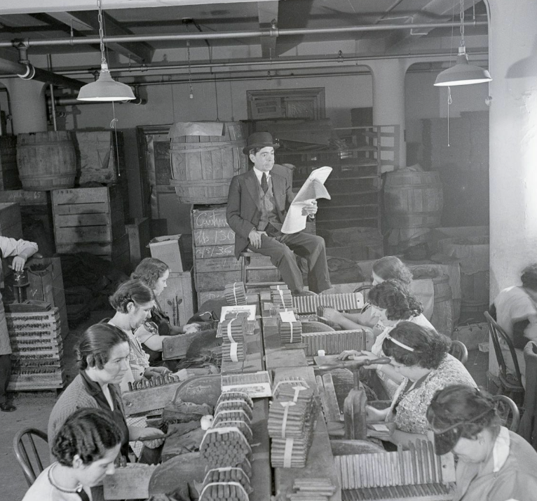 man reading newspaper to cigar workers